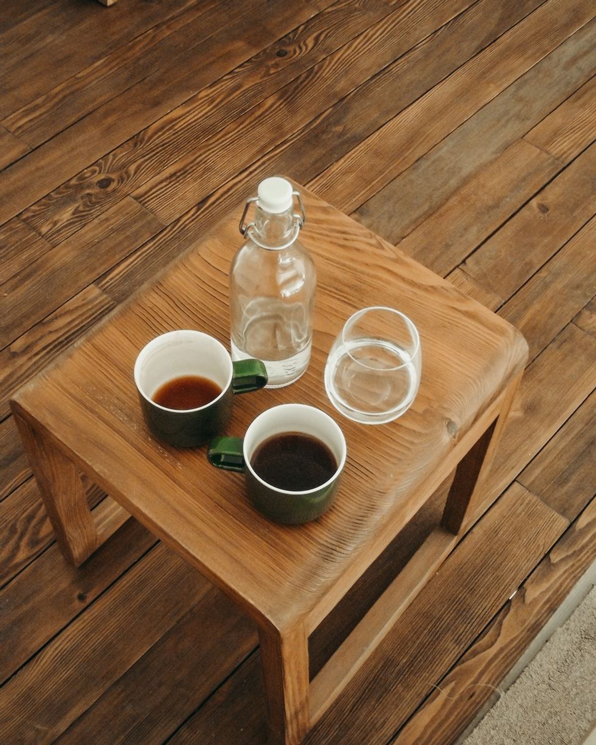 Ishi Coffee Table with a honed grey basalt top on a natural oak base, three-quarter view.