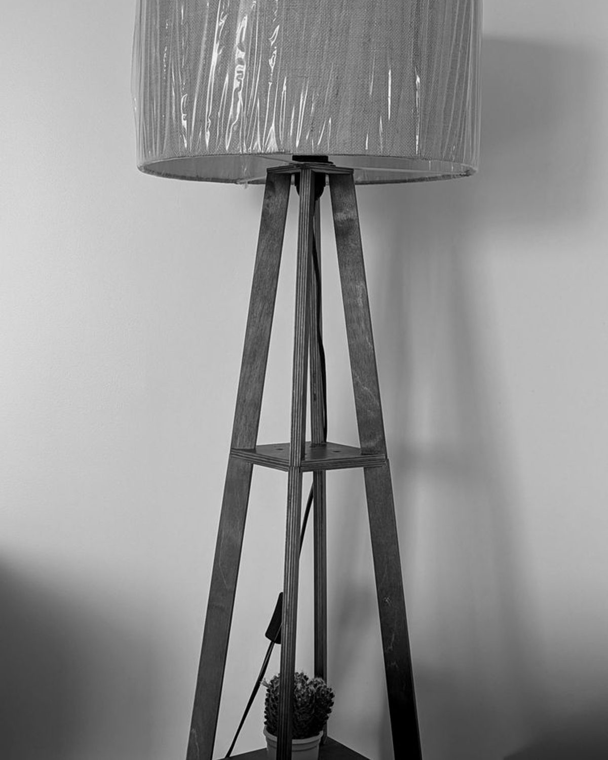 Kage Floor Lamp with an oak stem and natural linen shade, three-quarter view on a neutral studio background.